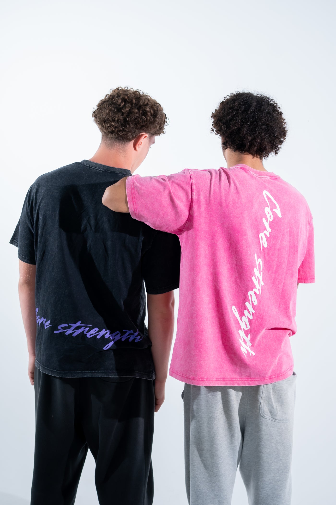 Two team members showing the violet and pink back prints